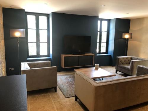 un soggiorno con divani e TV a schermo piatto di La Maison Des Vignes ***** a Volnay