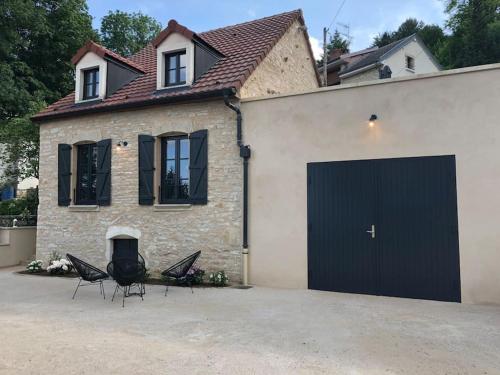 uma garagem com duas cadeiras em frente a uma casa em La Maison Des Vignes ***** em Volnay