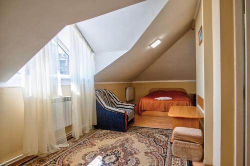 Schlafzimmer im Dachgeschoss mit einem Bett und einem Fenster in der Unterkunft Вілла Калина in Truskawez