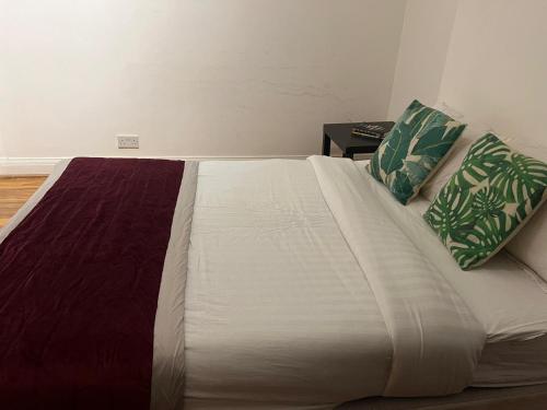 a large bed with two pillows on it in a room at Dayrooms in Norbury