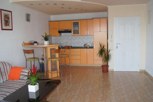 a living room with a kitchen with orange cabinets at Vila Slatine - Beach Apartments in Slatine