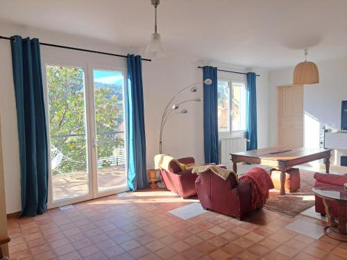 uma sala de estar com uma mesa e cadeiras e portas de vidro deslizantes em L'Autre Maison em Cotignac