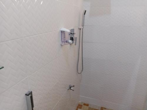y baño con ducha y aseo. en Dexxy's Palace Hotel, en Koforidua