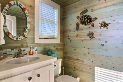 a bathroom with a toilet and a sink at Ruby Redbird Roost in Port Aransas