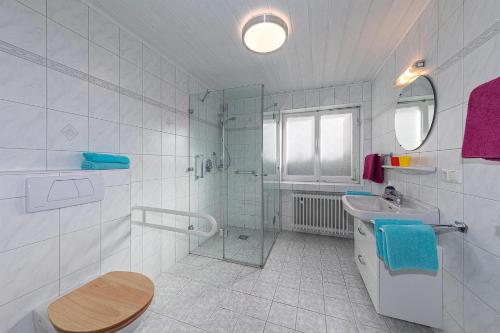 baño blanco con ducha y lavamanos en Ferienwohnung Minge, en Mittenwald