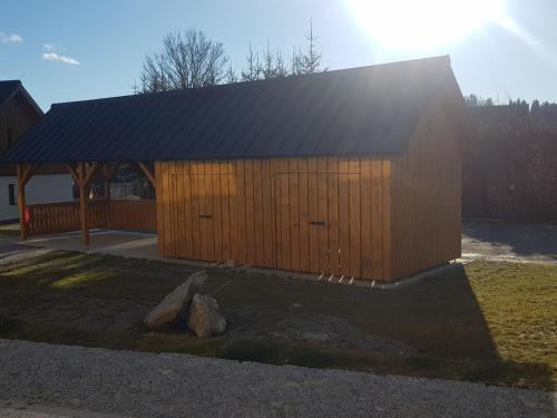 a large wooden building with a black roof at Barbora in Kašperské Hory