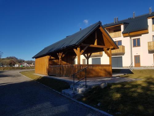 a building with a wooden pavilion next to a building at Barbora in Kašperské Hory