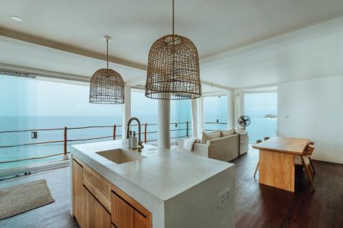 a kitchen with a sink and a living room at Bingin Low Tide in Uluwatu