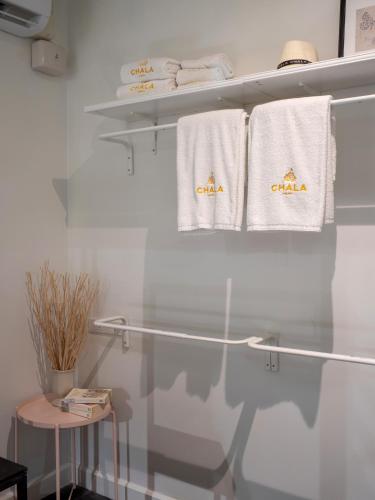 a bathroom with white towels hanging on a rack at Chala At Nimman in Chiang Mai
