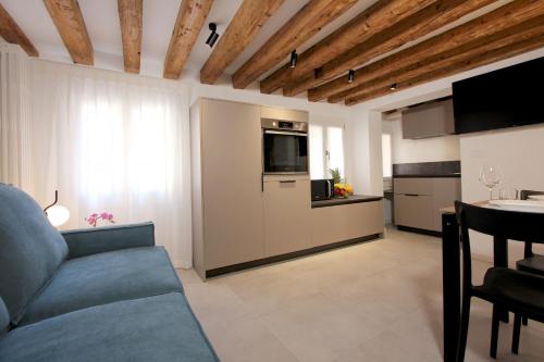 a living room with a blue couch and a kitchen at Residence Modern Art in Venice