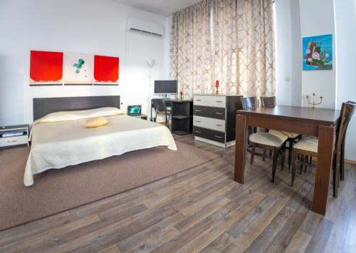 a bedroom with a bed and a desk and a table at Студио за четирима в село Ягодово, на 5 км от Пловдив и летище Крумово in Yagodovo