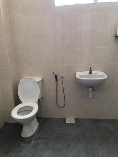 a bathroom with a toilet and a sink at HJ Homestay in Kuala Terengganu