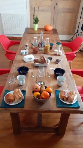 a wooden table with plates of food on it at Emilie une nuit - 3 chambres au 2e étage - maison avec chats in Vandières