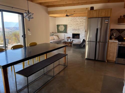 a kitchen and living room with a stainless steel refrigerator at Verdin's Nest - Romantic Retreat with Hot Tub Under the Stars! home in Morongo Valley