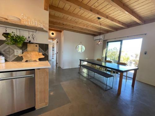 a kitchen and dining room with a dining table at Verdin's Nest - Romantic Retreat with Hot Tub Under the Stars! home in Morongo Valley