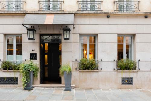 a building with a black door and potted plants at La Villa Madame in Paris