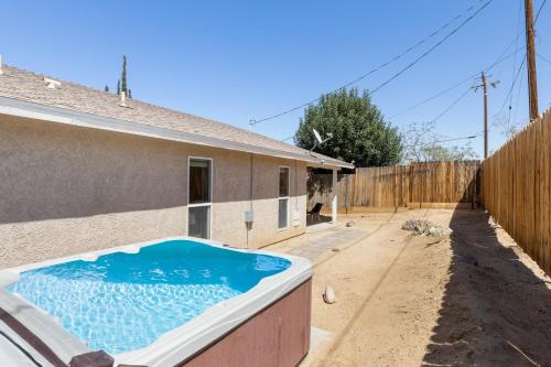 a swimming pool in the backyard of a house at Colorful Cactus - Hot Tub, BBQ and Fire Pit! home in Joshua Tree