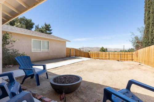une cour arrière avec deux chaises et un foyer dans l'établissement Colorful Cactus - Hot Tub, BBQ and Fire Pit! home, à Joshua Tree