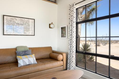 a living room with a couch and a large window at Relax in Style at The Green Jackrabbit - Hot Tub, Record Player home in Sunfair Heights