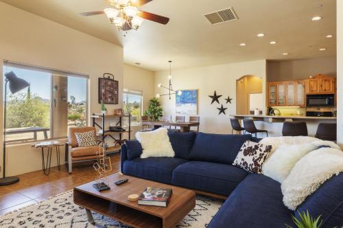 a living room with a blue couch and a kitchen at Horizon House - Hot Tub, Fire Pit & BBQ - Adobe in JT home in Joshua Tree