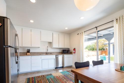 a kitchen with white cabinets and a wooden table at The RockHopper - Hot Tub, Fire Pit & Walk to Downtown JT! home in Joshua Tree