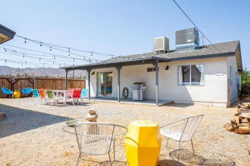 a patio with chairs and a table and a house at The RockHopper - Hot Tub, Fire Pit & Walk to Downtown JT! home in Joshua Tree