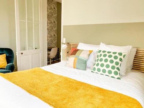 ein Schlafzimmer mit einem großen Bett und einer gelben Decke in der Unterkunft Appartement lumineux centre Cognac avec terrasse in Cognac