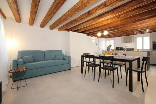 a living room with a blue couch and a table and chairs at Residence Modern Art in Venice