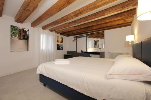 a bedroom with a large white bed with wooden ceilings at Residence Modern Art in Venice