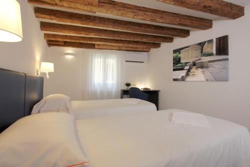 a bedroom with two white beds and a wooden ceiling at Residence Modern Art in Venice