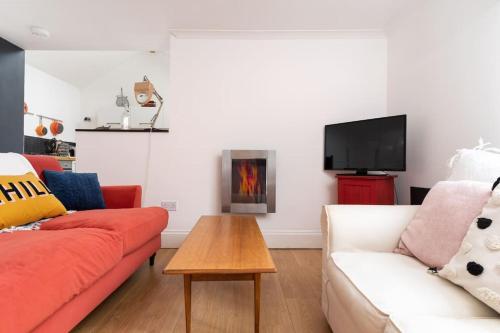 a living room with a couch and a fire place at Stylish Cornish Village 3 bedroom house old Newlyn in Newlyn
