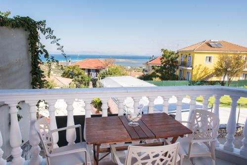y balcón con mesa y sillas de madera. en Villa Joanna apartments en Lefkada