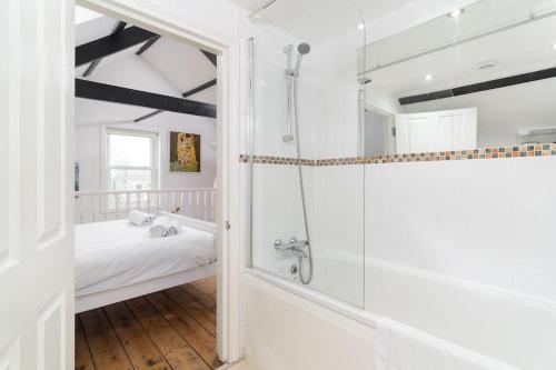 a white bathroom with a shower and a bed at Stylish Cornish Village 3 bedroom house old Newlyn in Newlyn
