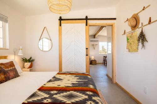 a bedroom with a bed and a door to a hallway at Flamingo Ranch - Dreamy Desert Design with Hot Tub home in Pioneertown