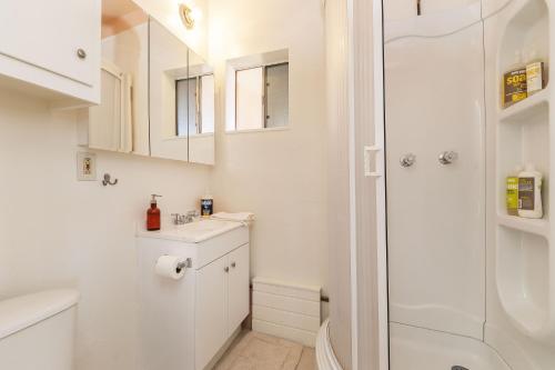 een witte badkamer met een douche en een wastafel bij Red's Ranch - Rustic and modern JT home base home in Joshua Tree