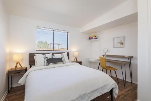 a bedroom with a large white bed and a desk at Walpi Ranch - Joshua Tree Getaway with Hot Tub, Fire Pit & BBQ! home in Joshua Tree