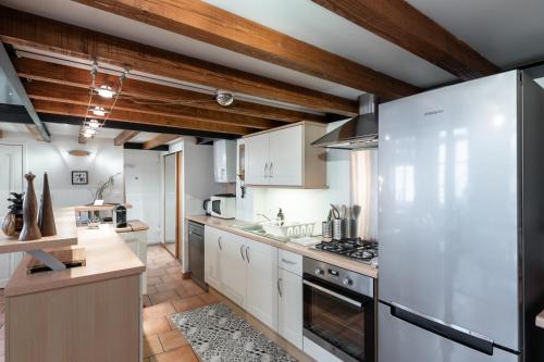 - une cuisine avec des appareils blancs et des plafonds en bois dans l'établissement L'Atelier de Pierre - Charmant T4 à la Croix Rousse, à Lyon