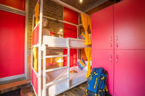 a bedroom with pink walls and a bunk bed at goSTOPS Pondicherry Near Auroville in Auroville