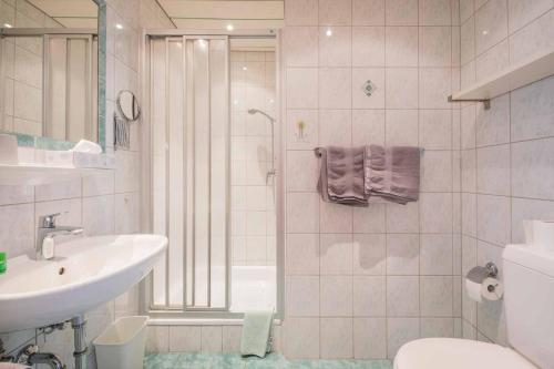 a bathroom with a shower and a sink and a toilet at Haus Hubertus in Mieders