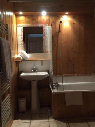 a bathroom with a sink and a bath tub at Paisible chalet montagne avec option jacuzzi in Séez