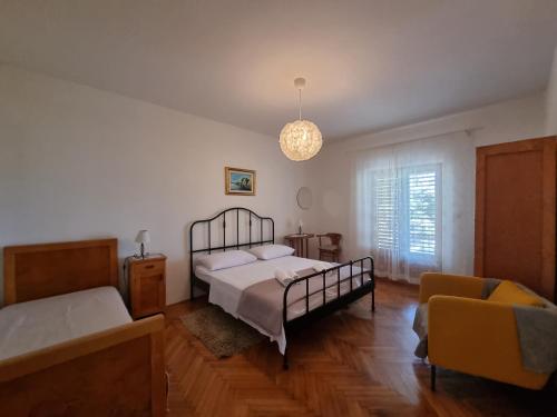 a bedroom with a bed and a couch at Cozy apartments with seafront terraces in Omiš