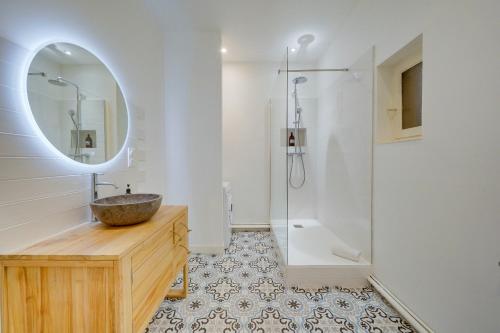 une salle de bain avec un lavabo, un miroir et une douche dans l'établissement LE 61 - Superbe T2 meublé avec balcon en plein cœur de Bordeaux, à Bordeaux