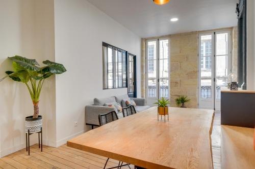 un salon avec une table en bois et un canapé dans l'établissement LE 61 - Superbe T2 meublé avec balcon en plein cœur de Bordeaux, à Bordeaux