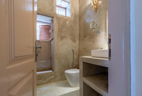 a bathroom with a toilet and a sink at Sharazad Wonders Boutique in Zanzibar City