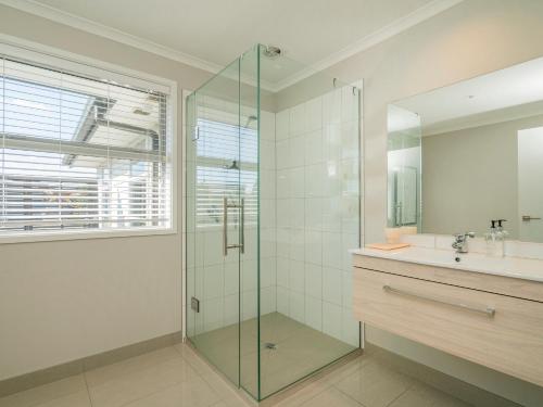 a bathroom with a glass shower and a sink at Relax on Roseberry - Whitianga Holiday Home in Whitianga