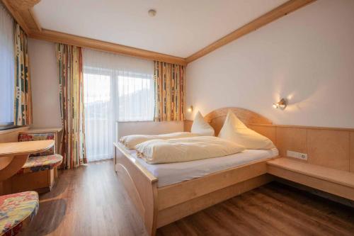 a bedroom with a bed with a large window at Haus Hubertus in Mieders