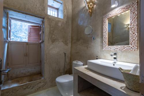 a bathroom with a sink and a toilet and a mirror at Sharazad Wonders Boutique in Zanzibar City