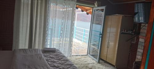 a bedroom with a sliding glass door with a view of the ocean at Rosa B&B in Lin