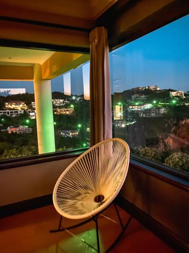 a wicker chair sitting in front of a window with a fan at Villa Seaview in Knysna