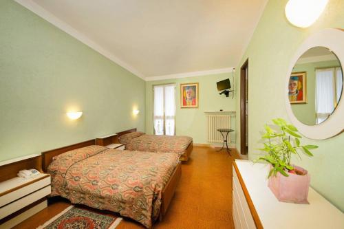 Habitación de hotel con 2 camas y espejo en Albergo Ponte di Nava, en Ormea